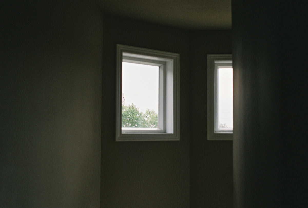 a room with two windows and a toilet